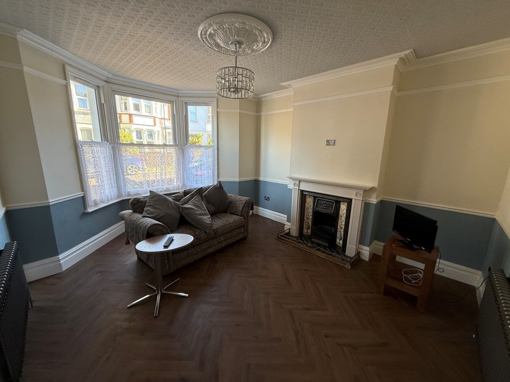 Lot: 132 - THREE-BEDROOM TERRACE HOUSE - Living room with bay window and fireplace